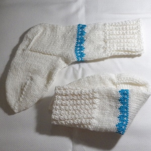 K&ouml;nnte beinhalten: Ein Paar wei&szlig;e Stricksocken mit einem blauen Streifen am oberen Rand jeder Socke.