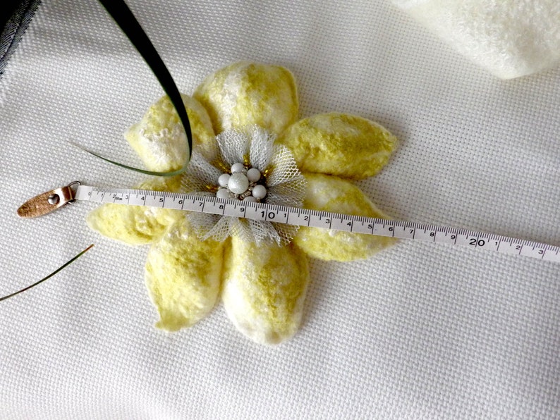 以下が含まれることがあります： パールとビーズのセンターが付いた黄色と白のフェルトの花のブローチ。メジャーで測定すると、幅は約10インチです。