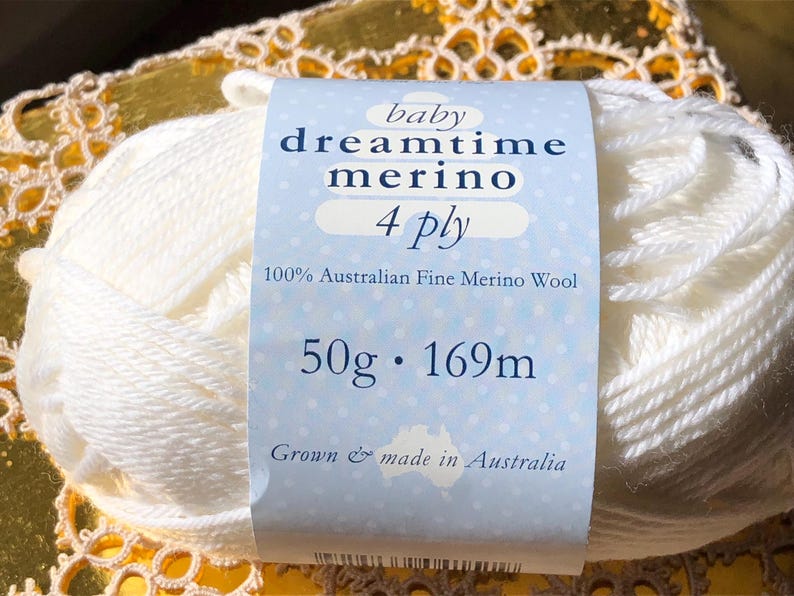 May include: A skein of white Baby Dreamtime Merino 4 ply yarn. The label reads "100% Australian Fine Merino Wool" and "50g &bull; 169m". The yarn is made in Australia.