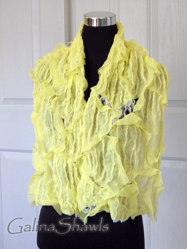 May include: A bright yellow ruffled scarf made of wool. The scarf is draped over a mannequin's shoulders. The text "Galina Shawls" is visible at the bottom of the image.