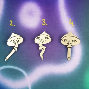 May include: Five wooden mushroom-shaped ornaments with different facial expressions. Each ornament is numbered 1 through 5.