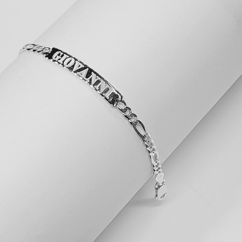 May include: A silver chain bracelet with a nameplate that reads "GIOVANNI".