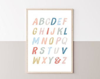 May include: A printable alphabet poster with colorful letters in a brushstroke style. The letters are arranged in alphabetical order and are in shades of pink, blue, yellow, and orange. The poster is framed in a light wood frame and has the text "PRÊT-À-PRINT" at the bottom.