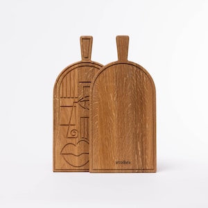 oak cutting board with carved line-art pattern on white background