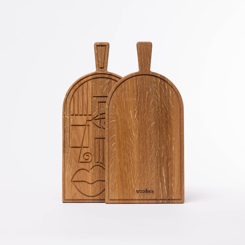 oak cutting board with carved line-art pattern on white background