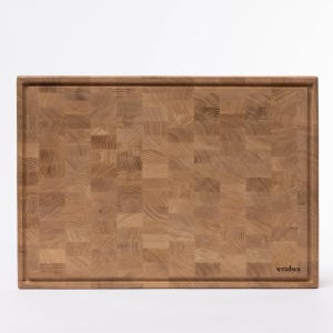 May include: A large, rectangular, wooden cutting board with a checkered pattern. The board is made of light brown wood and has a slightly raised edge. The brand name "woodsea" is printed in the lower right corner.