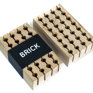 May include: Two wooden organisers with a grid of holes for storing small items. The organiser on the left has a black label that says "BRICK".