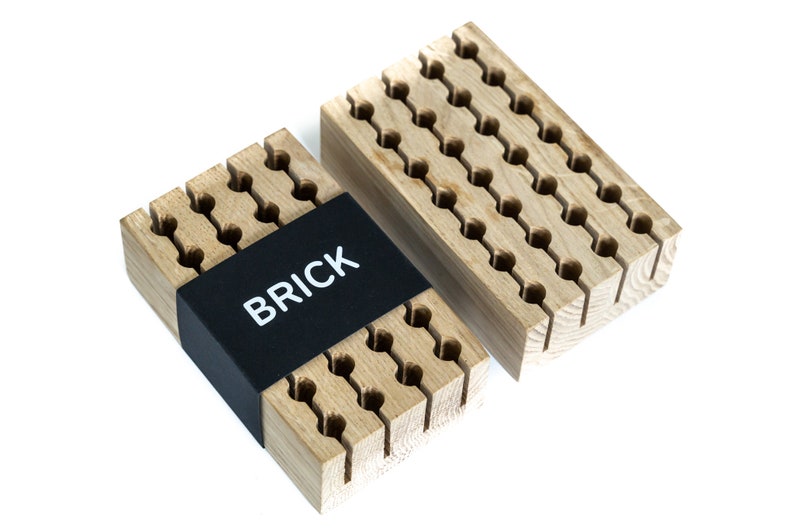 May include: Two wooden organisers with a grid of holes for storing small items. The organiser on the left has a black label that says "BRICK".