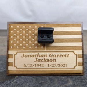 Small wooden plaque with stand that hold bullet casing for funeral