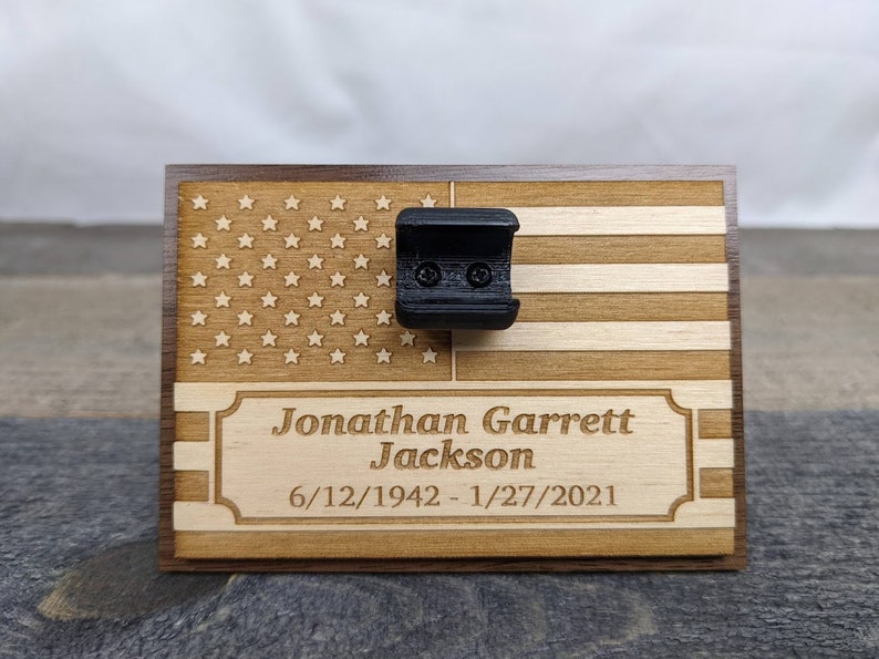 Small wooden plaque with stand that hold bullet casing for funeral