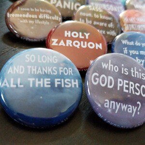Pu&ograve; includere: Una collezione di spille colorate con varie frasi, tra cui "So Long and Thanks for All the Fish", "Holy Zarquon", "Who is this God Person anyway?", "I seem to be having tremendous difficulty with my lifestyle" e "SASS noun. to know; to be aware of; to be aware of: ex with".