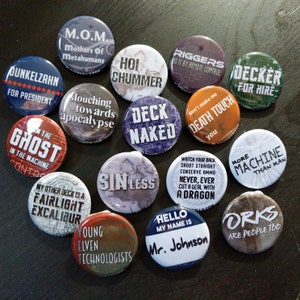 May include: A collection of 14 round, colorful buttons with various cyberpunk-themed slogans and illustrations. The buttons feature phrases like "Deck Naked", "More Machine Than Man", "Orks Are People Too", and "Young Elven Technologists".