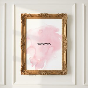 May include: A framed print with a gold ornate frame. The print features a pink watercolor design with the word "whatever" in black text. The artwork is mounted on a white wall.