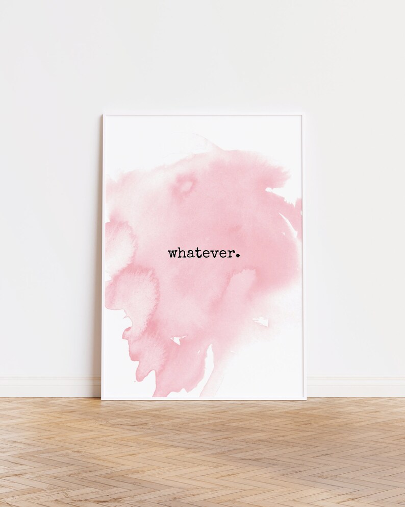 May include: White framed art print featuring a soft pink watercolor design. The word "whatever" is printed in black, centered on the artwork. The print is displayed against a white wall and a wooden floor.