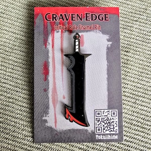 May include: A black enamel pin depicting a sword with a red handle. The pin is on a card with the text "CRAVEN EDGE Critical Role Enamel Pin" and a QR code. The card has a red and black background.