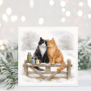 Peut inclure: Illustration à l'aquarelle de deux chats, un noir et blanc, l'autre roux, assis côte à côte sur une barrière en bois dans un paysage enneigé. Une thermos et deux tasses sont posées sur la barrière. L'image évoque une scène hivernale chaleureuse.