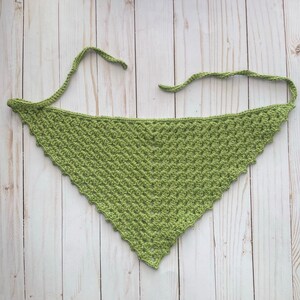 May include: A green crocheted triangle scarf with a scalloped edge.