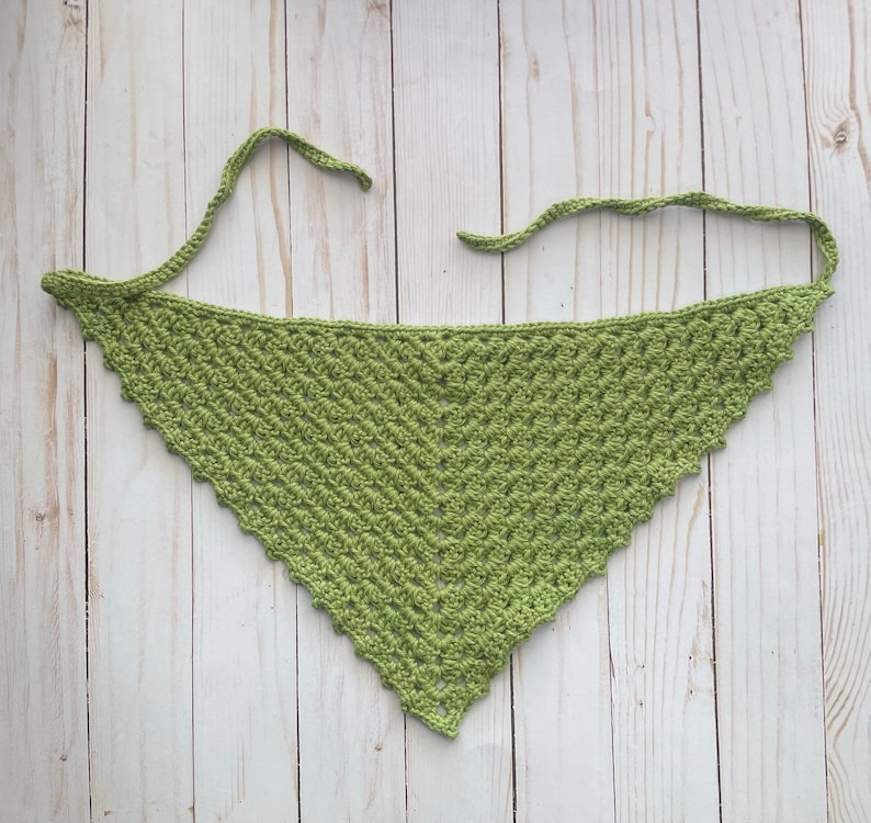 May include: A green crocheted triangle scarf with a scalloped edge.