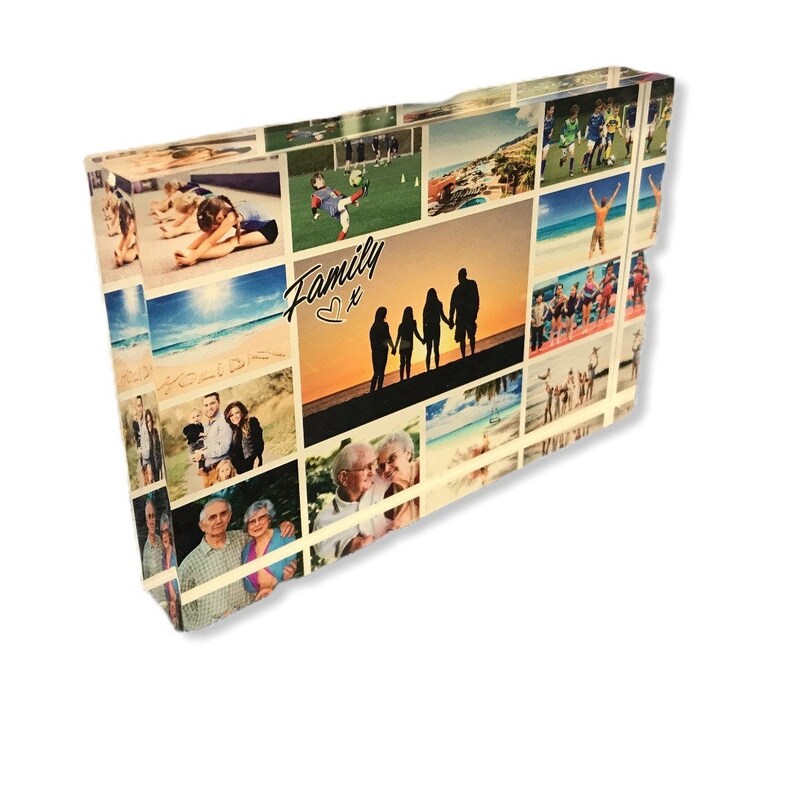 May include: A collage of family photos printed on a clear acrylic block. The photos show a variety of people and places, including a family of four silhouetted against a sunset, a group of people on a beach, and a couple standing in front of a building. The text "Family" with a heart symbol is printed on the block.