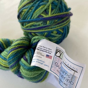 May include: A ball of green, blue, and purple yarn with a label that reads "Artyarns Suyarns 100% merino" and includes the website www.artyarns.com.