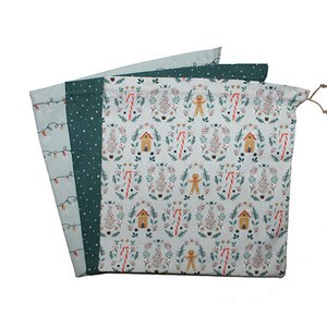 May include: Three Christmas-themed drawstring bags. One bag features a pattern of Christmas lights, another has a dark green polka dot pattern, and the third displays a festive design with gingerbread men, candy canes, and houses.