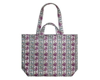 May include: A white tote bag with a floral pattern. The bag has two handles and a wide base.