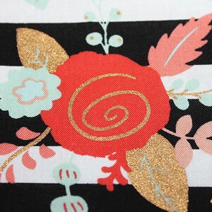May include: Black and white striped fabric with a red, gold, and pink floral pattern. The fabric features a large red rose with a gold swirl design.