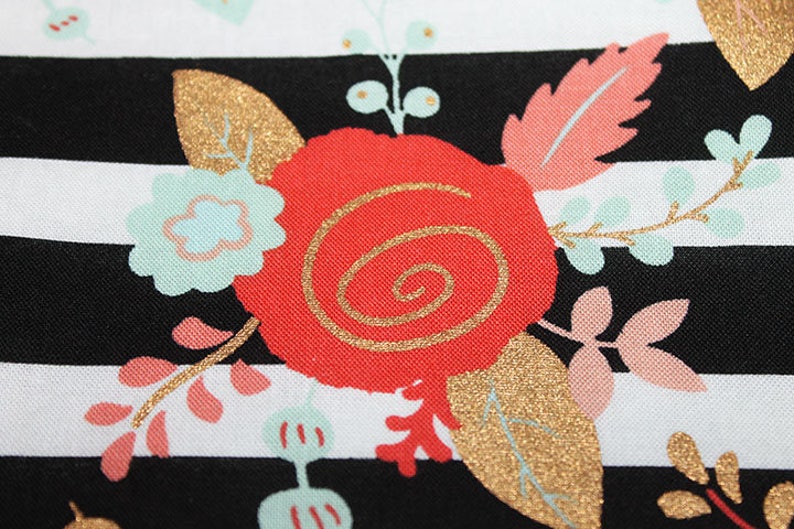 May include: Black and white striped fabric with a red, gold, and pink floral pattern. The fabric features a large red rose with a gold swirl design.