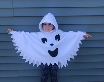May include: A white ghost costume with a black smiling face and jagged edges. The costume is made of fleece and has a hood.