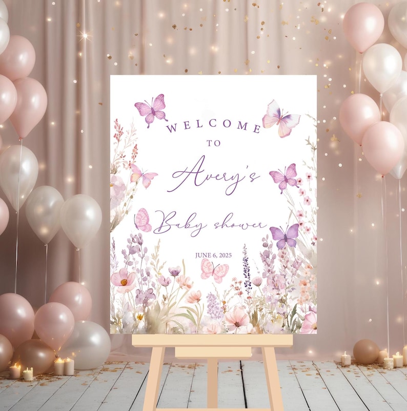 May include: Welcome to Avery's Baby Shower sign with a floral design featuring butterflies and lavender. The sign is printed on white cardstock and has a purple and pink color scheme. The date of the shower is June 6, 2025.