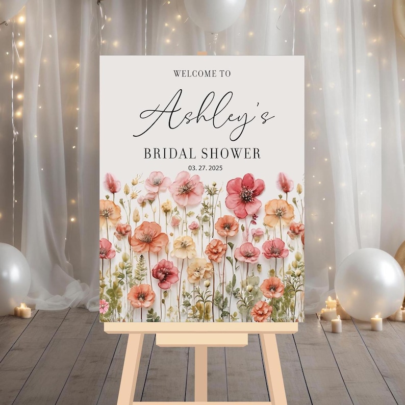 May include: Welcome to Ashley's Bridal Shower sign with a watercolor floral design in shades of pink and orange. The date of the shower is March 27, 2025.
