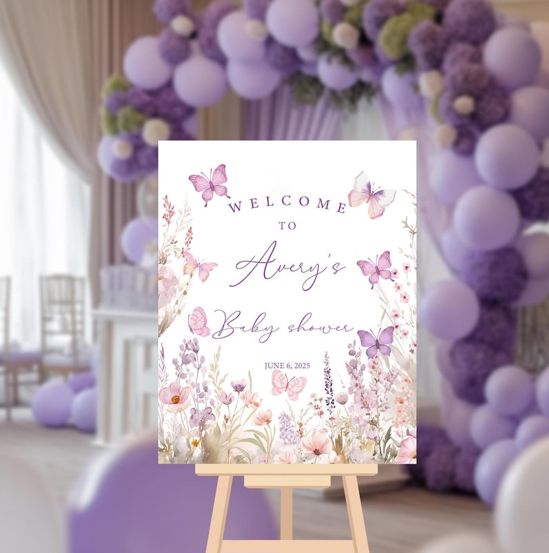 May include: Welcome to Avery's Baby Shower sign with a watercolor floral design featuring butterflies and lavender. The sign is on a wooden easel and the date is June 6, 2023.