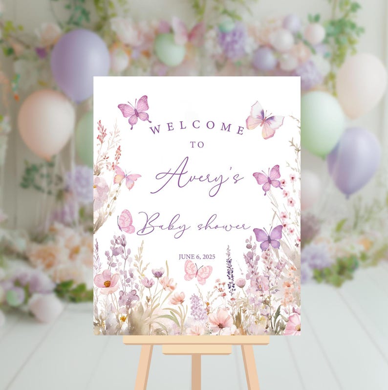 May include: Welcome to Avery's Baby Shower sign with a purple and white floral design and butterflies. The sign says "Welcome to Avery's Baby Shower" and "June 6, 2023".