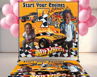 May include: A vibrant orange backdrop with the text "Start Your Engines" and a large number 4. The backdrop features cartoon race cars and the Hot Wheels logo. Two children are positioned in front of the backdrop, with pink balloons on either side.