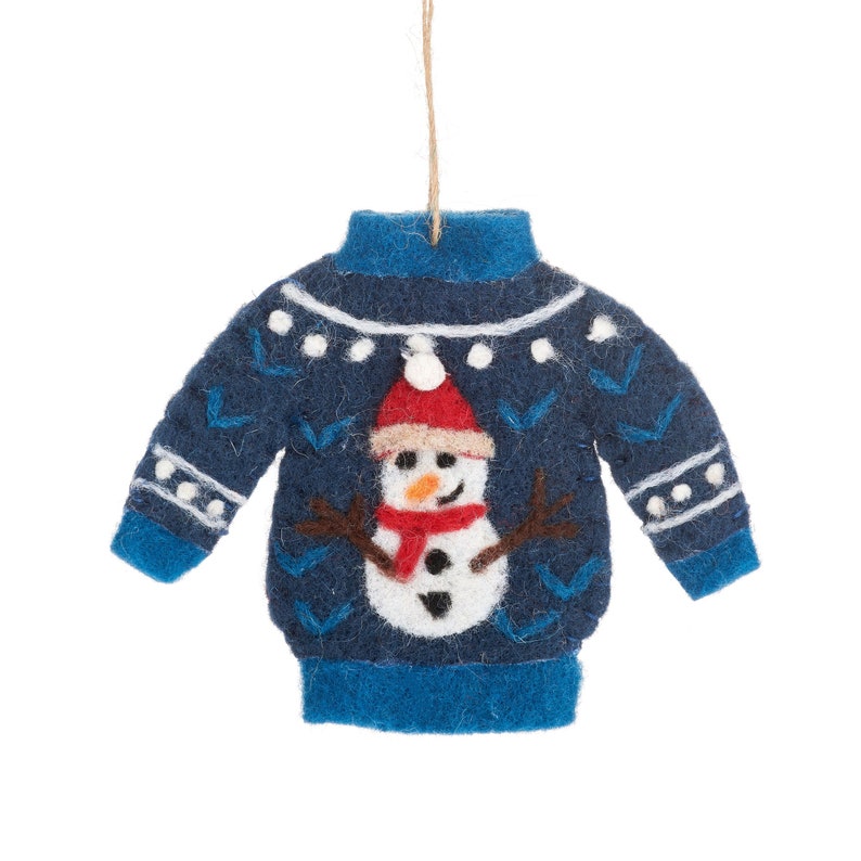 May include: Blue felt Christmas ornament shaped like a sweater with a snowman design. The snowman is wearing a red hat and scarf.