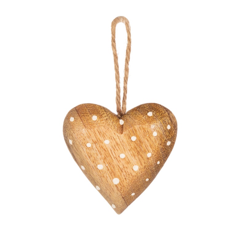 Pu&ograve; includere: Un ornamento di legno a forma di cuore con pois bianchi e un gancio di spago.