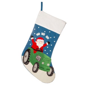 Könnte beinhalten: Ein blauer Weihnachtssocken mit weißem Bündchen zeigt eine gestickte Abbildung des Weihnachtsmanns, der einen grünen Traktor mit den Worten "Ho Ho Ho" in Weiß fährt.