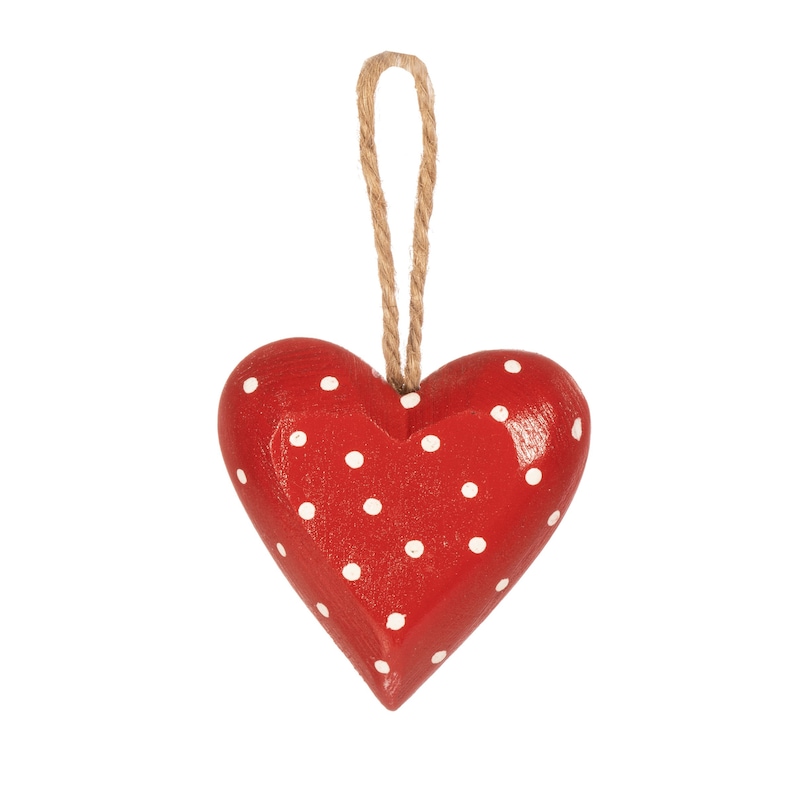 May include: A red wooden heart with white polka dots hanging from a twine string.