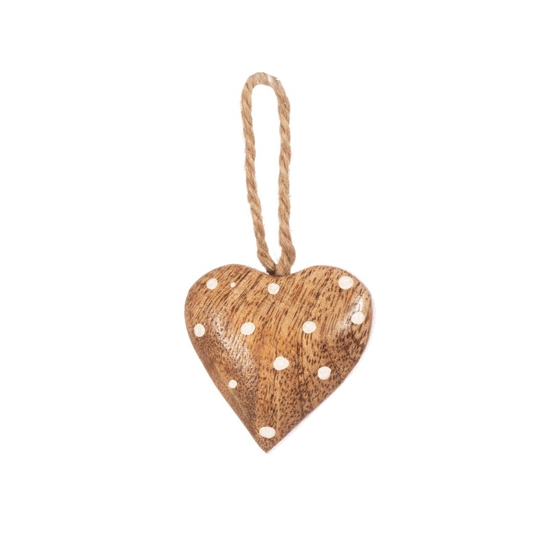Puede incluir: Adorno en forma de coraz&oacute;n de madera con acabado de vetas naturales y lunares blancos. El adorno est&aacute; suspendido por un lazo de cuerda natural. El coraz&oacute;n es un art&iacute;culo decorativo, adecuado para colgar o exhibir.