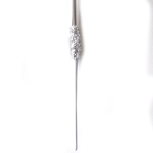 May include: A silver cake server with a cluster of sparkling crystals near the handle. The server has a long, slender design and is set against a white background. The crystals add a touch of elegance.