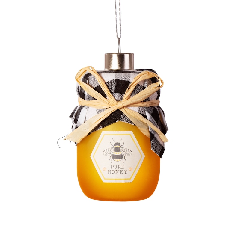 May include: A glass jar ornament shaped like a honey jar with a black and white checkered fabric bow and a bee and "PURE HONEY" label.
