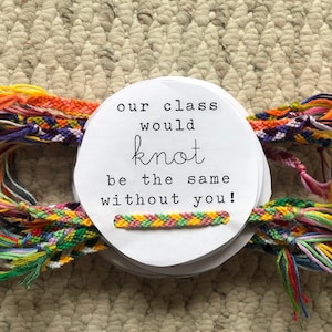 May include: A white card with the text "our class would knot be the same without you!" surrounded by colorful friendship bracelets.