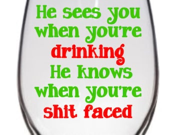 He sees you when you're sleeping.  He knows when your shit faced. Funny Holiday Bar Glasses - Wine and Pub glasses available.