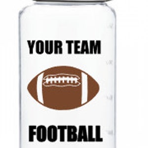 Puede incluir: Botella de agua de pl&aacute;stico transparente con tapa negra y asa de transporte negra. La botella tiene un gr&aacute;fico de f&uacute;tbol blanco y el texto "YOUR TEAM FOOTBALL".