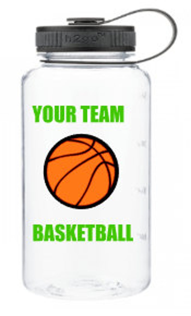 Puede incluir: Botella de agua de pl&aacute;stico transparente con tapa negra y asa de transporte. La botella tiene un gr&aacute;fico verde de un bal&oacute;n de baloncesto con el texto "YOUR TEAM BASKETBALL" impreso en ella.