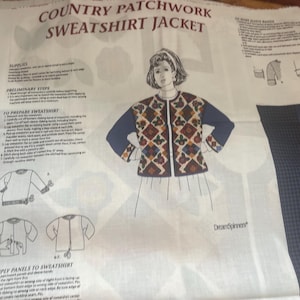 May include: A white sewing pattern sheet titled Country Patchwork Sweatshirt Jacket featuring black text instructions and line drawings. The central illustration shows a person wearing a dark blue jacket with a colorful geometric patchwork front panel.