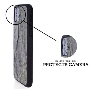 Puede incluir: Una funda de tel&eacute;fono negra con un borde elevado para proteger la c&aacute;mara. La funda tiene un patr&oacute;n de piedra en tonos grises y verdes.