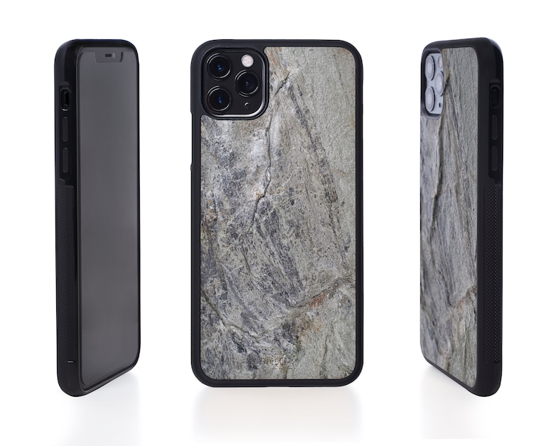 Puede incluir: Funda de tel&eacute;fono negra con un patr&oacute;n de piedra gris y blanca. La funda tiene una protuberancia de c&aacute;mara elevada y un borde negro.