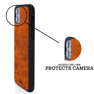Op de afbeelding: Een bruine leren telefoonhoes met een verhoogde rand rond de camera lens. De hoes heeft een textuur en een zwarte rand. De tekst "RAISED LIPS 1 MM PROTECTS CAMERA" staat onderaan de afbeelding.