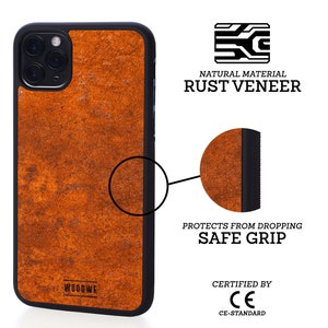 Op de afbeelding: Een telefoonhoesje in roestkleur met een zwarte rand en een getextureerd oppervlak. De hoes is gemaakt van natuurlijk roestfineer en heeft een veilige grip om je telefoon te beschermen tegen vallen. Het is CE-gecertificeerd.
